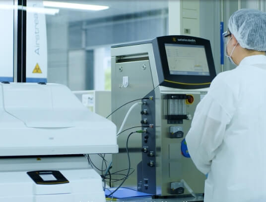 A man in a lab coat is working on a machine.