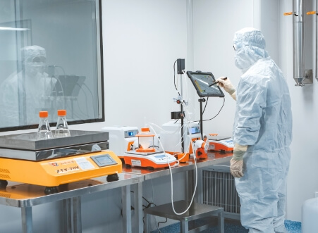 A man in a protective suit is working in a laboratory.